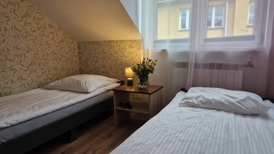Dwa łóżka pojedyncze i szafka nocna pod skosem