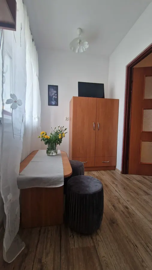 Pokój z szafą, telewizorem i stolikiem przy oknie